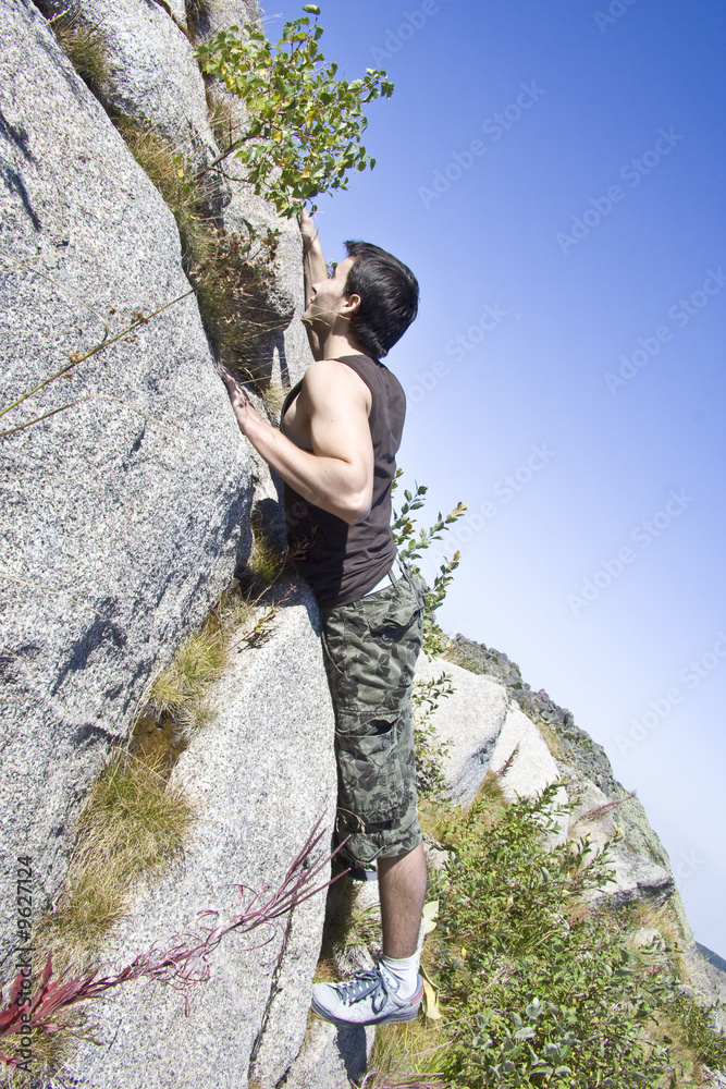 Young and strong boy climbing a mountain Young and strong boy climbing a mountain