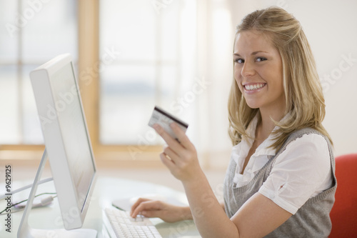 Smiling Woman shopping online with credit card and computer © edbockstock