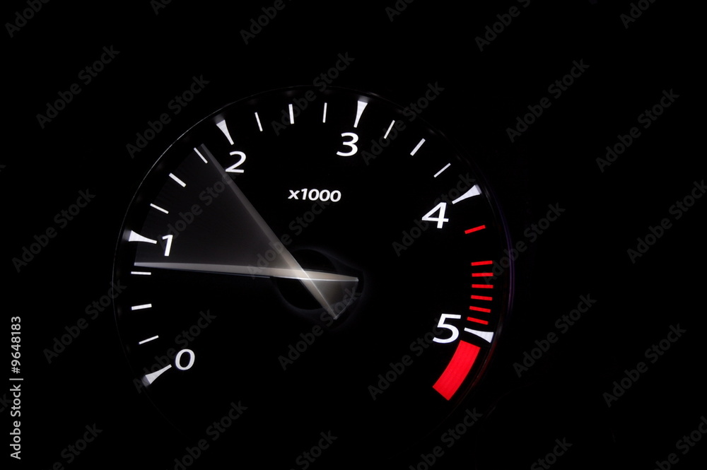 moving revs meter of a sports car on a black background.