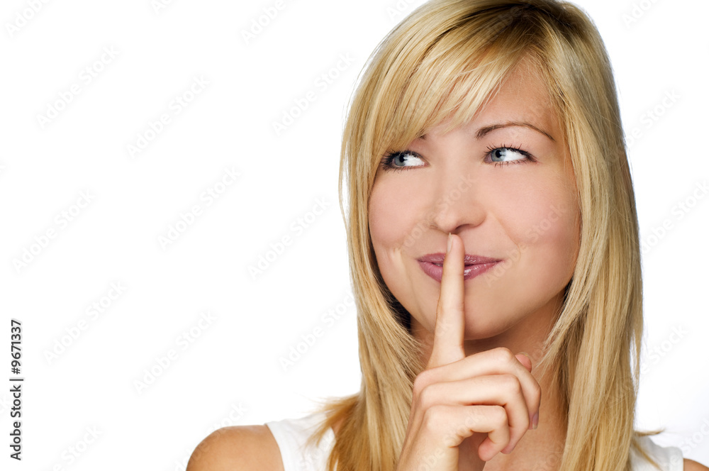 Young blond woman with her finger over her mouth Young blond woman with her finger over her mouth