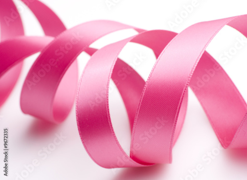 Pink ribbon curling on white background