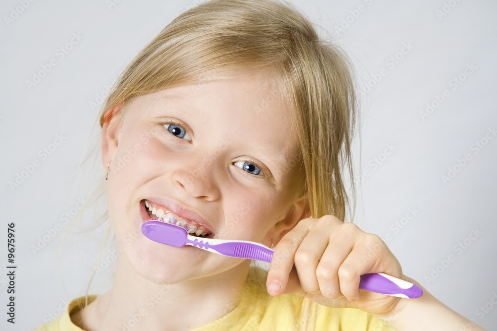 Little girl wearing colorful t-shirts brushing teeth Little girl wearing colorful t-shirts brushing teeth