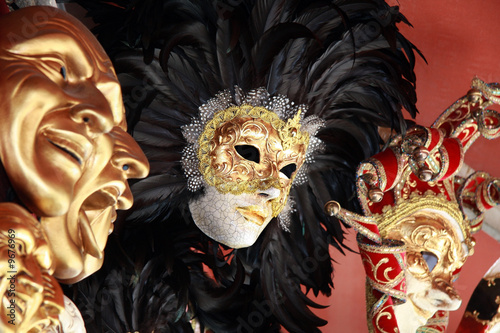 Venetian masks with black feathers on a red background photo