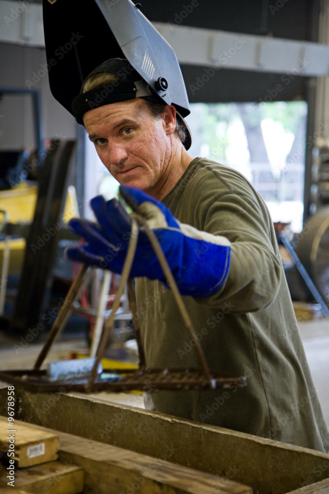 Metal worker in a factory wearing his welding visor.