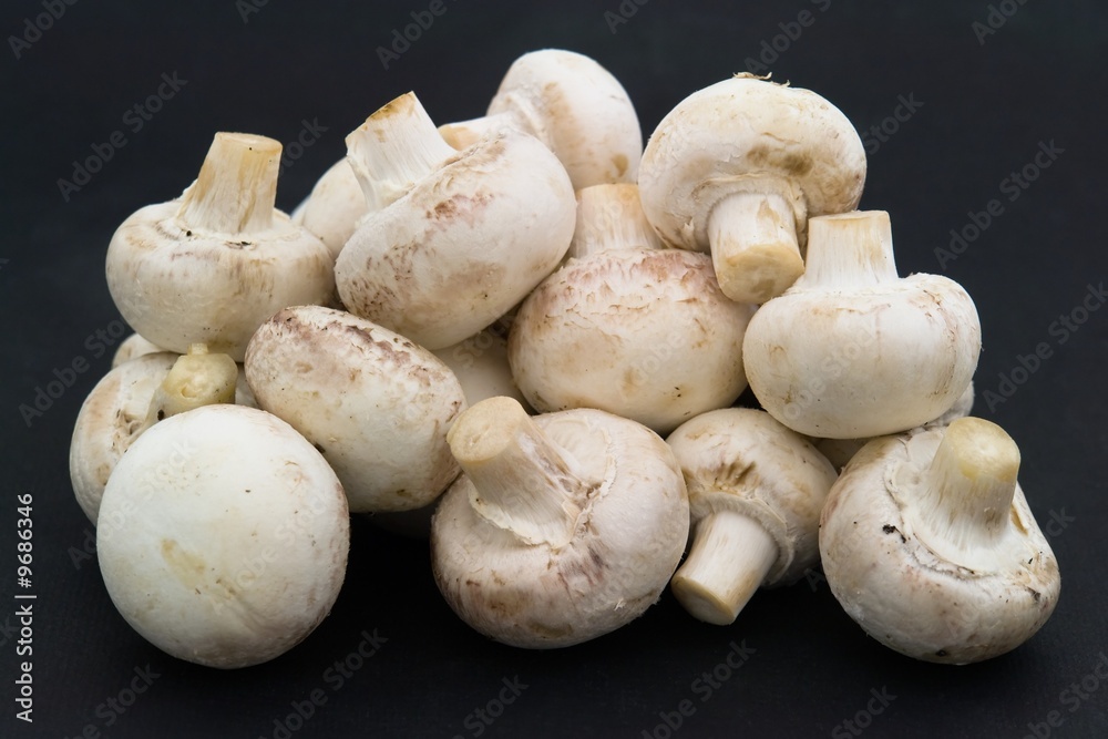 Mushrooms. Heap of champignons on a black background Mushrooms. Heap of champignons on a black background