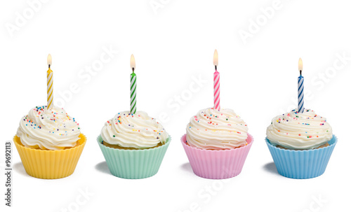 Four cupcakes with candle on white background