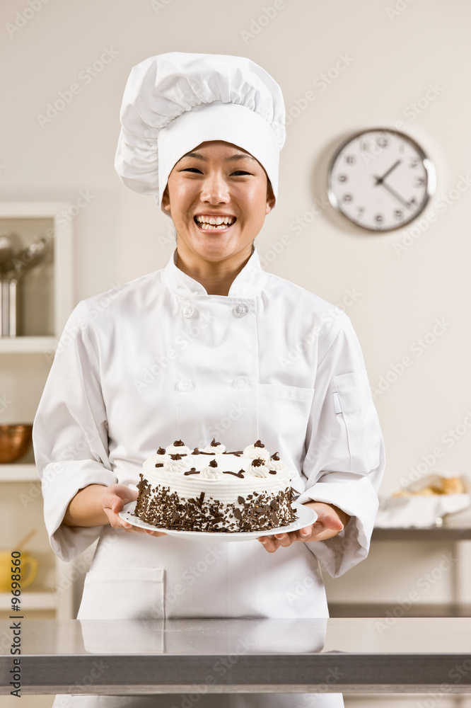 Bakery chef in toque proudly holding birthday cake Stock Photo | Adobe Stock