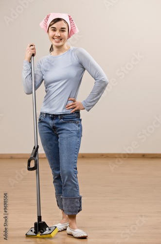Fotografija Happy housewife wearing headscarf and holding mop