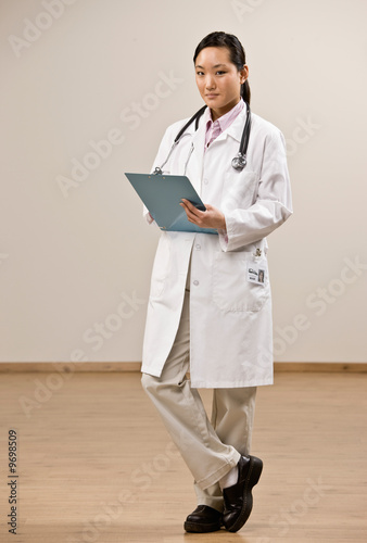 Confident doctor wearing lab coat holding medical chart