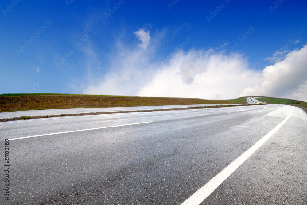 highway and white clouds in  dark blue sky