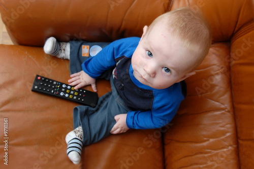 Little baby boy playing with TV remote