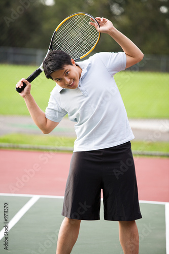 A young asian male stretching before playing tennis © arekmalang