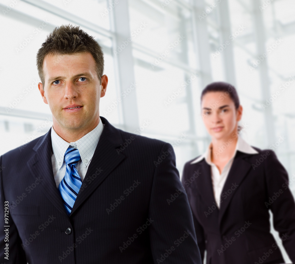 Businessman and businesswoman standing at office lobby. Businessman and businesswoman standing at office lobby.