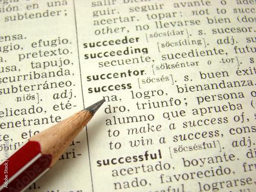 'success' word in english-spanish dictionary with pencil
