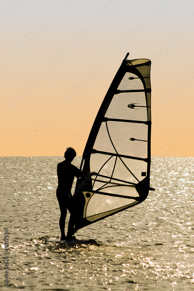 Naklejka premium Silhouette of a windsurfer on waves of a gulf