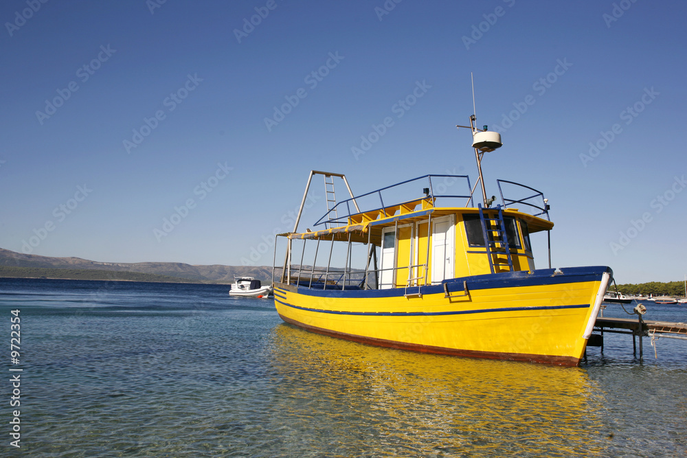 Yellow diving boat in harbour on Brac island in Croatia Yellow diving boat in harbour on Brac island in Croatia