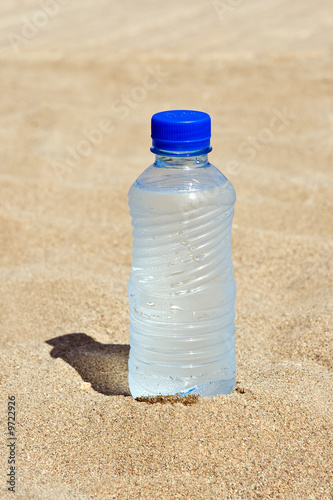 Plastic bottle with water on sand