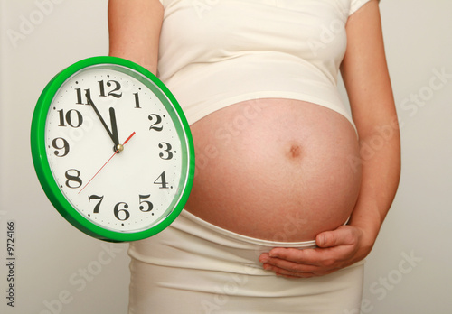 Pregnant woman with a clock
