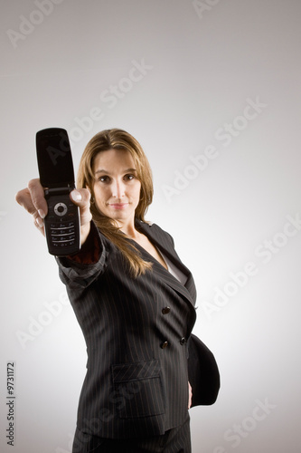 Confident businesswoman holding out cell phone