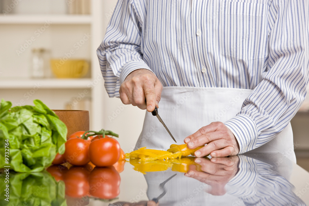 Man preparing wholesome salad in kitchen for dinner Man preparing wholesome salad in kitchen for dinner
