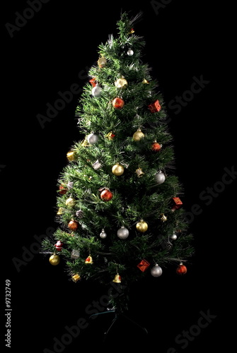 Decorated Christmas-tree on black background .