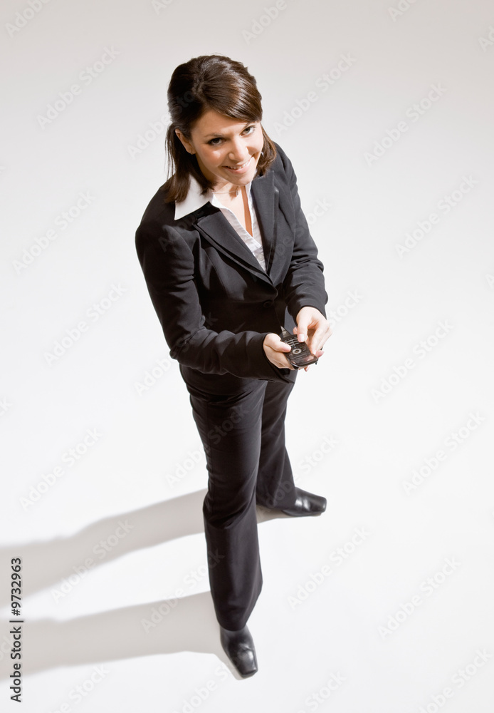 Confident businesswoman text messaging on cell phone Confident businesswoman text messaging on cell phone