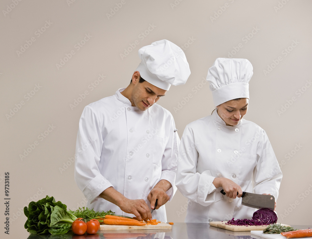 Chefs whites preparing and chopping fresh vegetables Chefs whites preparing and chopping fresh vegetables