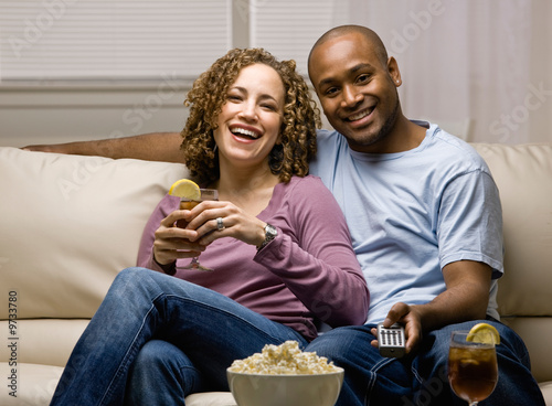 Relaxed couple with popcorn and remote control