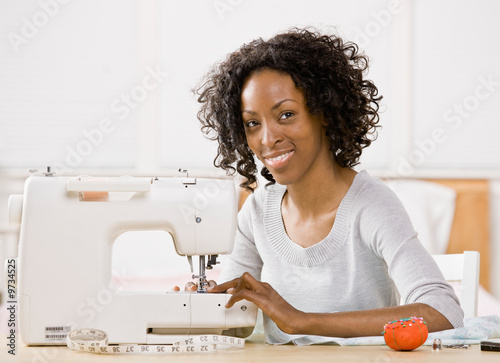 Creative woman using sewing machine to sew clothing