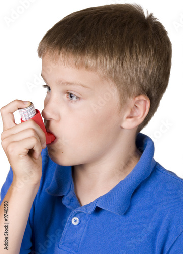 Asthma inhaler being used by boy in blue shirt