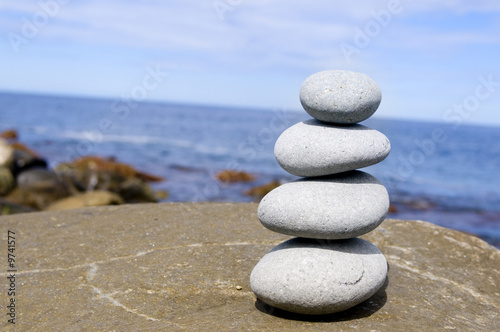 Four stones balanced on a large rocky beach