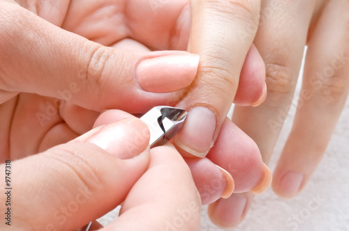 nail salon, manicure applying  - cuticle cutting photo