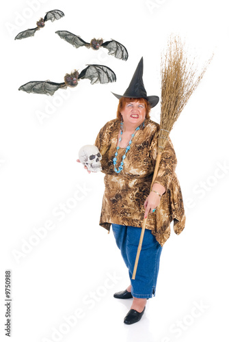 Self confident obese middle aged female witch with bats. photo