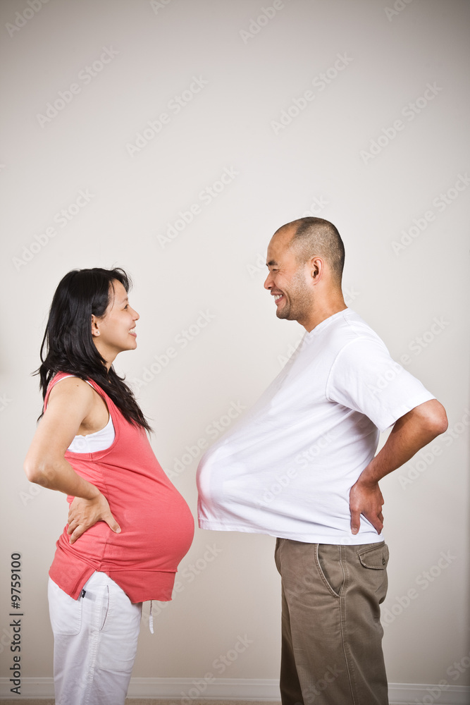 A happy expecting pregnant asian couple facing each other A happy expecting pregnant asian couple facing each other