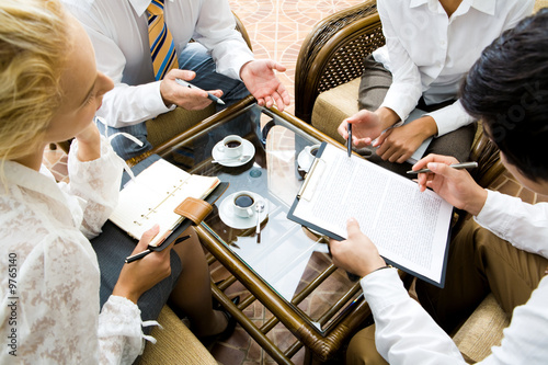 Close-up of businesspeople discussing a plan at meeting photo