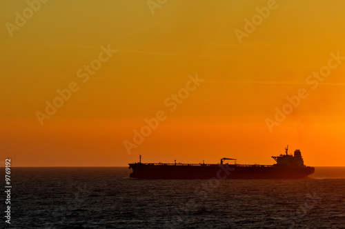 cargo ship by sunset at the ocean © Ivonne Wierink