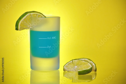 Shot Glass With Blue Tequila Liquor Shooter and Lime Slices