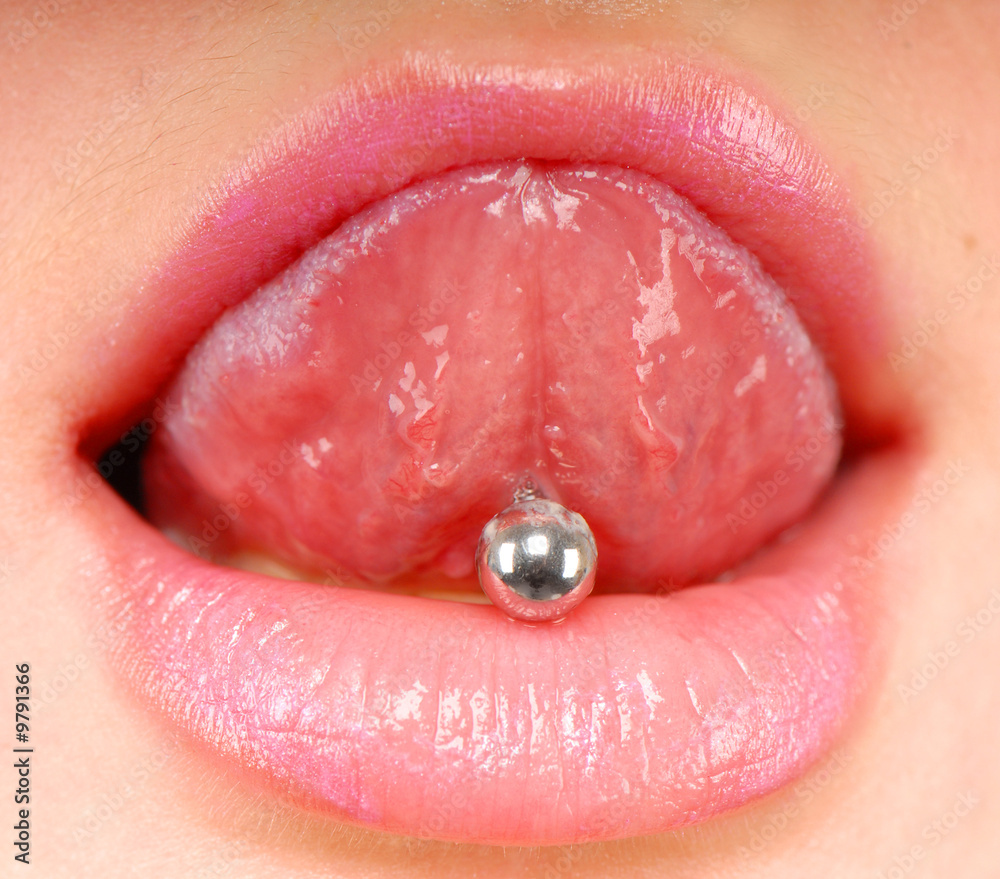 Fototapeta premium woman sticking out her tongue to show piercing
