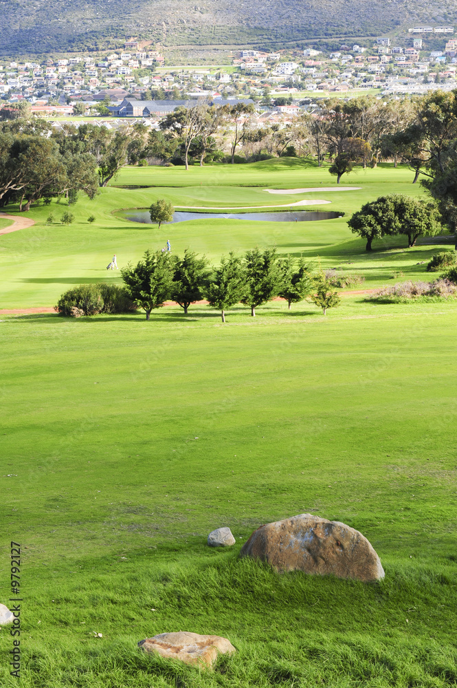 Obraz premium A picturesque golf course nestled between mountains.