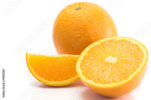 Whole, halved and quartered oranges, isolated on white.