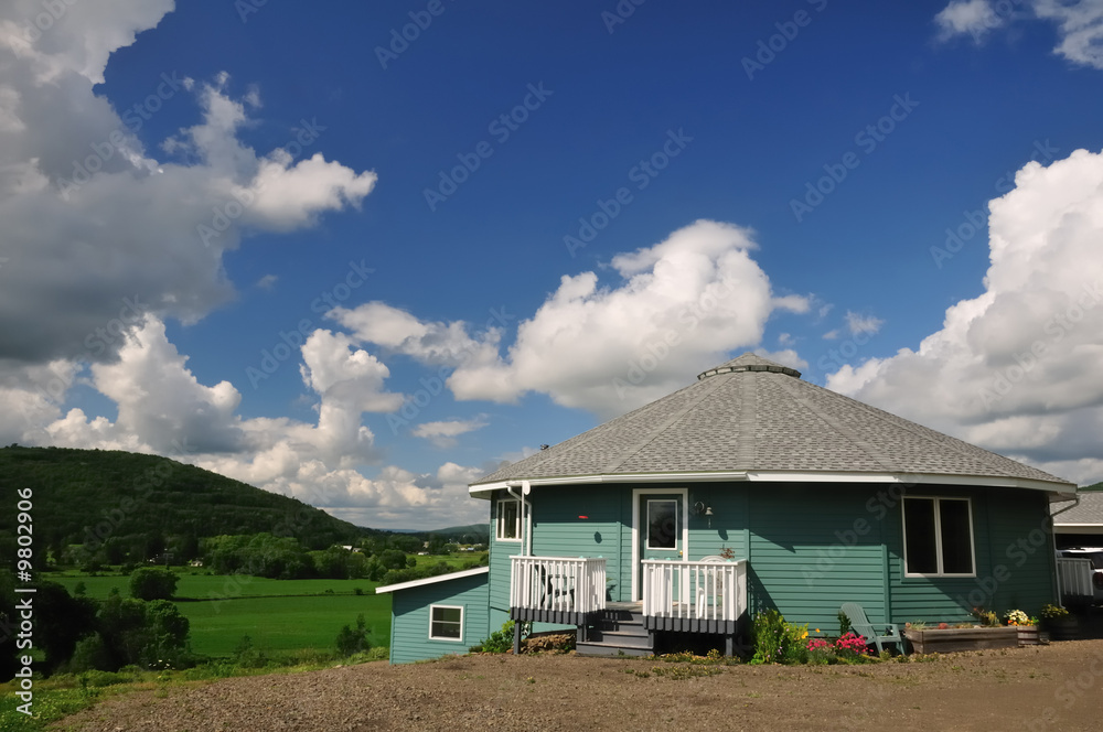 Obraz premium A sixteen-sided house overlooking a lush green river valley