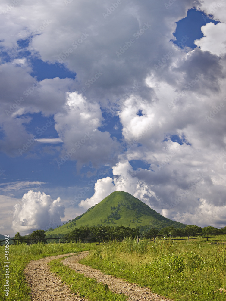Obraz premium green mountain under blue sky with quaint clouds