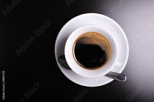 Top view of a white cup of coffee on black background