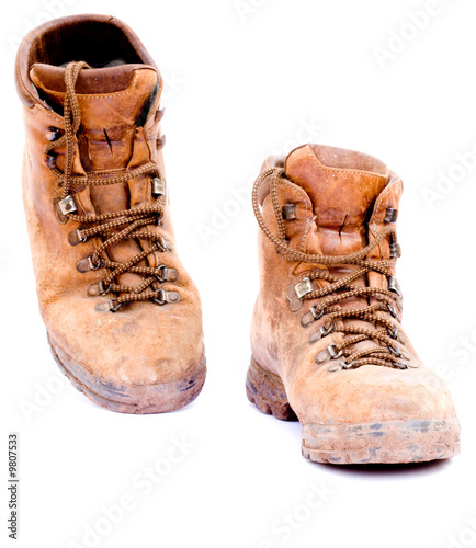 A pair of old worn walking boots isolated on a white background