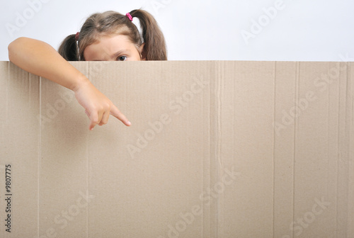 Little girl behind a blank cadboard