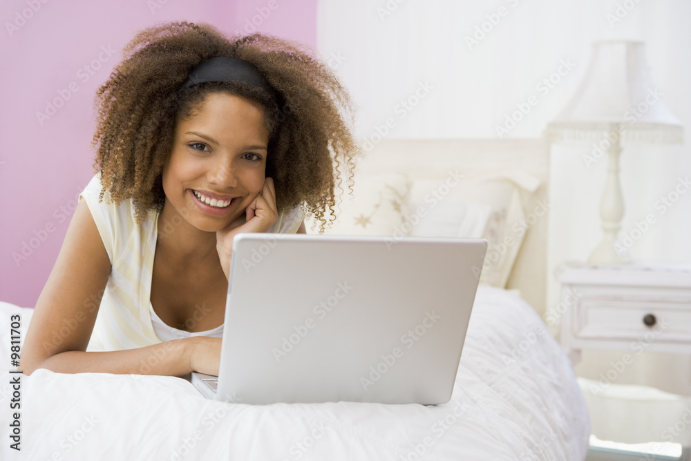 Teenage Girl Lying On Bed Using Laptop Teenage Girl Lying On Bed Using Laptop