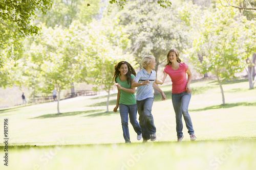 Fototapeta Naklejka Na Ścianę i Meble -  Teenagers Running Through Park