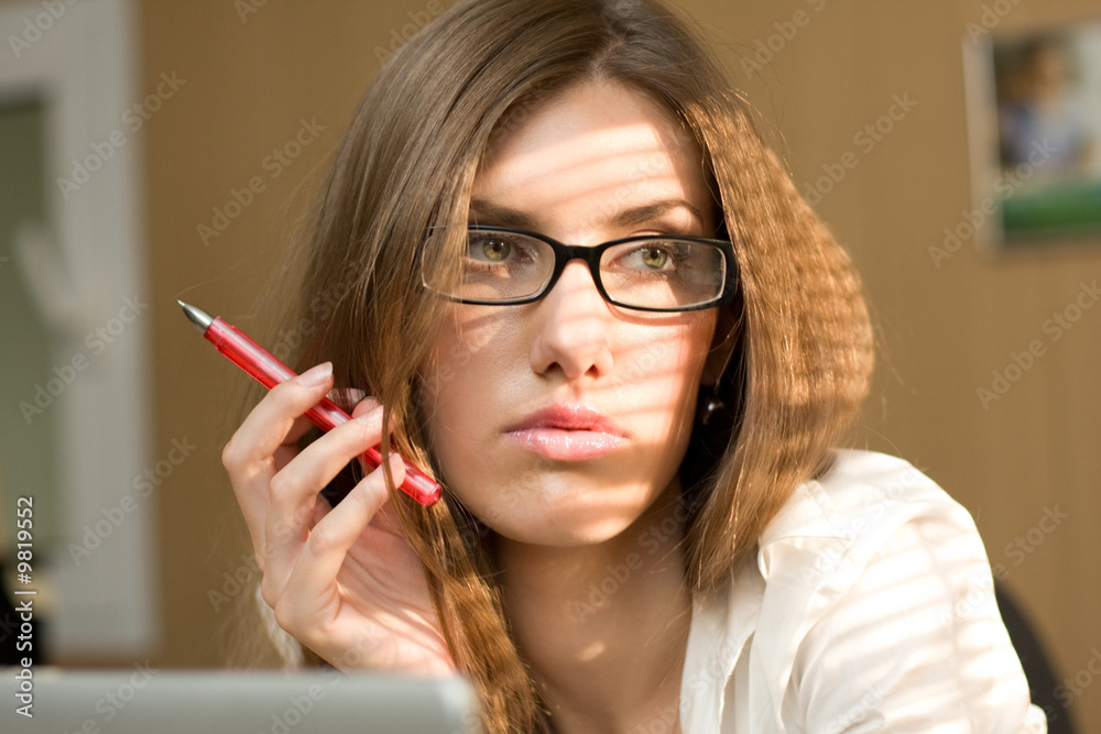 Close-up of serious woman with pen in hand Close-up of serious woman with pen in hand