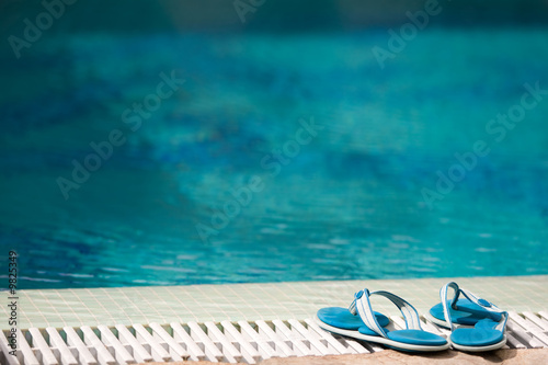 two blue slippers near swimming pool in hotel