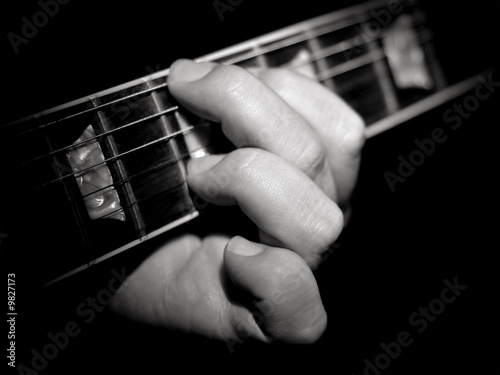 Obraz na plátne Guitar player fretboard playing chords on black background